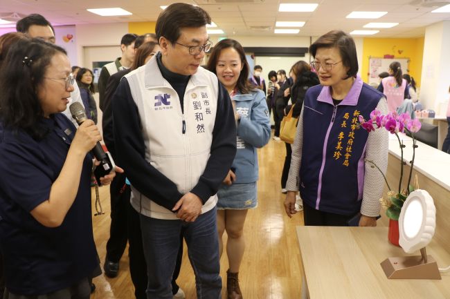 《圖說》五股成州身障日照中心主任江明芬（左1）為劉和然介紹採用40赫茲（Hz）的貝殼燈，可穩定心智障礙者的情緒。〈社會局提供〉