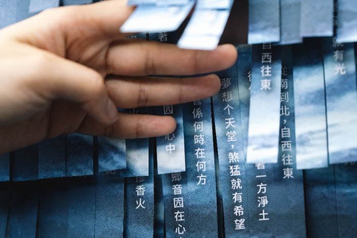 《圖說》新北市立圖書館總館的客家閱讀專區，以剪紙層次堆疊出起伏波濤的「剪紙堆疊詩牆」，使並呈現客籍詩人王興寶的作品《夢想个天堂》。〈客家局提供〉