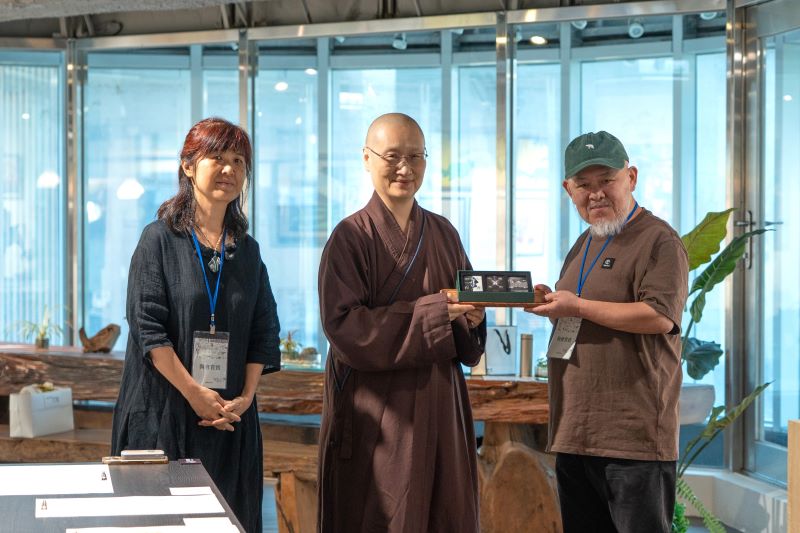 《圖說》世界宗教博物館發展基金會執行長顯月法師(中)致贈宗教和諧卡給多寶藝術學堂。〈宗博館提供〉